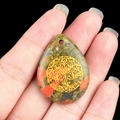 Hand holding water drop unakite stone pendant with golden Tree of Life engraving - Unakite