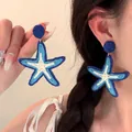 Detail of hand-woven oversized starfish earrings with blue and white fringe tassels - 13# Blue Woven Pentagram (Steel Pin)