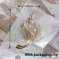 Gold leaf brooch with rhinestones and white pearl measuring 60mm by 20mm - Gold Leaf