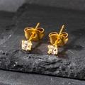 Detalle macro del pendiente de acero dorado de 3mm con circón redondo sobre piedra - 3mm / Dorado