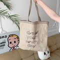 Détail du sac cabas en toile beige avec lettrage noir et détails de broderie verte - Khaki