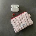 Close-up of quilted white cosmetic bag with red heart pattern and heart zipper pull - Heart Printed / White
