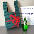 Knitted tote bag in dark green featuring red bows and Merry Christmas text - Dark Green Bow