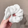 Oversized white satin scrunchie with pleated texture shown held in hand - White