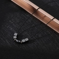 Detail view of hip hop cross necklace with metallic beads and cubic charms on black cord - XL20 / Minimalist Beads / Black