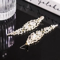 Gros plan de boucles d'oreilles pendantes dorées à pampilles avec cristaux pour soirées - Style Gland en Strass Clair / Tige d'oreille en argent-Blanc