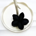 Matte black plumeria flower hair claw clip on a white ceramic plate for beach vacations - Rubber Paint Black