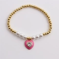 Elegante bracciale a sfere dorate con perle bianche e ciondolo a cuore in zircone rosa su bianco - Rosa