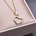 Detail of a minimalist gold hollow heart pendant necklace on a luxury jewelry box - Necklace / Gold