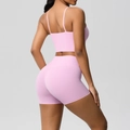 Detail of pink backless yoga top and high-waist shorts showing the seamless fabric texture - Sakura Pink