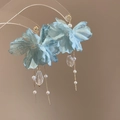 Detalle de pendientes de flores de tela azul con perlas y borlas de cristal sobre fondo beige - Pin de plata 925 / Azul