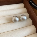 Macro shot of silver brushed round stud earrings on a beige velvet jewelry display - 60# Silver 14mm Brushed Ball Silver Earring Post
