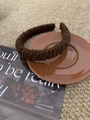 Close-up of thick knitted dark brown headband featuring warm autumn wool texture - Brown