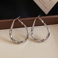 Gros plan de boucles d'oreilles torsadées en métal argenté en forme de goutte d'eau - Argent (Silver Earring Post)
