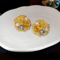 Macro view of vintage gold flower earrings with pearls and a faceted yellow gemstone - Gold (Silver Earring Post)