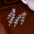 Dettaglio orecchini a fiore in argento con nappe a foglia di cristallo su velluto scuro - Stile Pendente Foglia Fiore / Argento