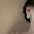 Close-up of a blue floral earring featuring yellow center on a model's ear - Yellow Pistil Blue Flower (8#)