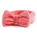 Detailopname van de roze koraalvlies hoofdband met zachte strik voor gezichtsreiniging - Watermeloen Rood