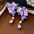 Detailed macro view of vintage purple floral earrings with crystal droplets and rhinestones - Purple