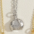 Gros plan du pendentif coccinelle en argent serti de zircons sur une chaîne en O maille - Coccinelle / Couleur Platine