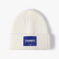 Gorro de punto blanco para invierno con una etiqueta azul de marca en el borde doblado - Talla única / Blanco