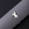 Macro shot of silver unicorn pendant bracelet displayed on a professional textured stand - Bracelet / Silver