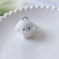 Détail macro d'un porte-clés chiot blanc floqué mignon avec texture douce et crochet - US 4