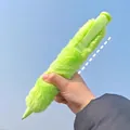 Penna a sfera gigante in peluche verde tenuta contro un cielo blu limpido all'aperto - Verde