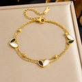 Detail of gold double-layered bracelet with black and white heart pendants and small beads - Black and White Heart Bracelet (B2026)