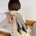 Beige lace embroidered large bow hair clip with long ribbons on a young girl - Lace Bow Hair Clip / Off White