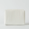 Close-up of a white quilted cosmetic bag featuring sleek vertical stitching and a zipper - White