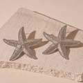 Close-up of silver starfish earrings with realistic textured surface on beige stone - 925 Sterling Silver Earring Post - Gold Pleated Starfish Stud Earrings