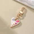 Golden heart keychain with colorful evil eye and flower prints on beige background - Colorful Graphic Style (7#)