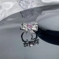 Close-up of silver bow ring featuring a pink heart-shaped gemstone on silk background - Style 3 Adjustable Ring