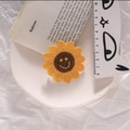 Handmade knitted sunflower hair clip featuring a smiling face on a yellow blossom - Yellow Smiley Flower