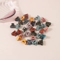 Close-up of colorful mini flower hair clips scattered on a soft pink surface - Semicircle Style / Bulk Packaging / Morandi Colors