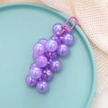 Dettaglio portachiavi a grappolo d'uva in acrilico viola cangiante su vassoio blu - Ciondolo / Viola