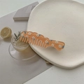 Detail eines süßen, orangefarbenen, lichtdurchlässigen Kamms mit Gänseblümchen-Muster - Orange