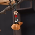Macro shot of hand-carved wood pumpkin and lotus pod keychain with colorful beads - Continuous Good Things Phone Chain