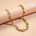 Dettaglio macro della collana flessibile con paillettes a cuore dorate sul supporto - Oro