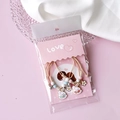 Pink and white woven bracelet set with rabbit charm and floral beads in OPP bag - Love Display Cards