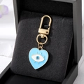 Golden heart-shaped devil eye pendant with blue enamel finish in black jewelry box - Blue Heart Eyelash Eye