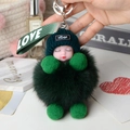 Close-up of fluffy green sleeping doll keychain with soft fox fur ball and LOVE ribbon - Dark Green