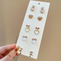 Dettaglio del set di cinque paia di orecchini dorati con gemme rosa e perle eleganti - Perno in Acciaio - Oro - Rosa (Set da 10)