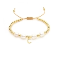 Detailed macro of Baroque pearl bracelet with golden beads and a letter C charm - Letter C