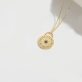 Golden sunburst disk pendant necklace with white zircon and black gemstone details - Star Moon Disc