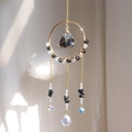 Modern rainbow suncatcher with black raw stone and crystal prism on golden metal ring - Obsidian