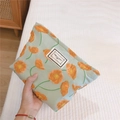Detail der hellgrünen Stofftasche mit orangem Mohnblumenmuster und gewebtem Etikett - Orange Trompetenblume