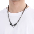 Detalle de collar para hombre con cabeza de dragón vintage sobre camiseta blanca - Color Acero
