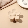 Close-up of cream matte floral claw clip on white porcelain plate with silk texture - Matte Flower Hair Clip - Beige
